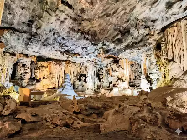 An empty, well-lit cavern inside the Cango Caves showing complex rock formations