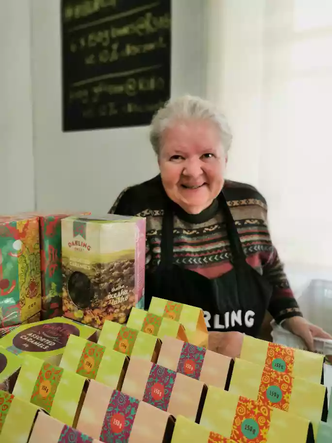 Local store host presenting hand-crafted artisanal sweets inside an organic storefront